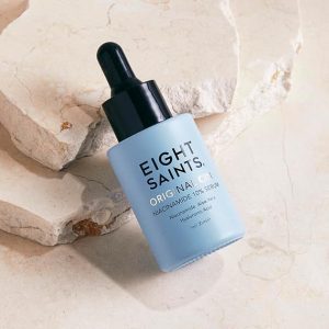 Eight Saints Original Niacinamide Serum bottle on a textured stone surface, featuring a dropper top, highlighting skin benefits such as brightening, hydration, and reduced fine lines.