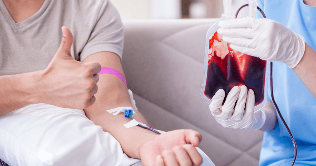 Man giving a thumbs up while donating plasma, with a healthcare professional holding a bag of collected blood, emphasizing health and wellness initiatives.